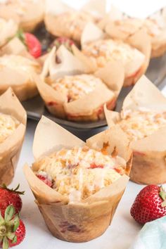 several muffins with strawberries on the side