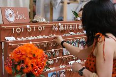 a woman in an orange dress is looking at jewelry