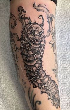 a tattoo on the leg of a person with an arm and legs covered in tattoos