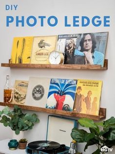 two wooden shelves with books on them and plants in front of the bookcases