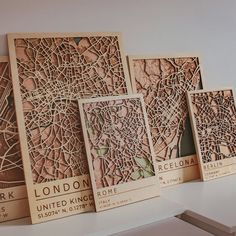 four wooden maps are displayed on a shelf