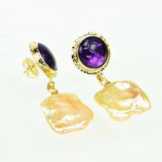 Baksa Notes Amethyst with Cacoxenite crystals are a rich purple. Golden Freshwater Keshi Pearls is a natural color. Bezel settings, with hammered texture frames. Design Details GOLD - 14k yellow BACKS - Jumbo with double notched posts GEMSTONE - Amethyst w/Cacoxenite CUT - Round cabochon CARAT - 15.80 ct. tw. SIZE - 14 mm PEARL - Golden Freshwater Keshi 20x22 mm OA DIMENSIONS - Length 49 mm Yellow Backs, Frames Design, Cabochon Earrings, Rich Purple, Keshi Pearls, Pendant Earrings, Bezel Setting, Earring Necklace, Natural Color