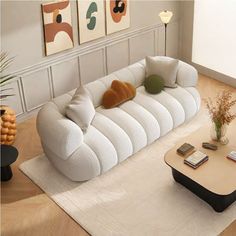 a white couch sitting on top of a living room floor next to a coffee table