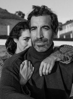 a man and woman are posing for a black and white photo with their arms around each other