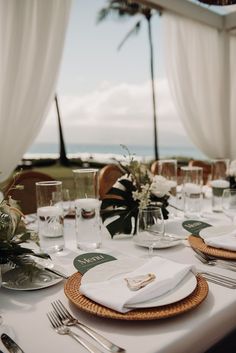 the table is set with place settings for two people to sit at, and there are palm trees in the background