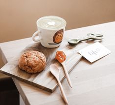 a wooden table topped with a cup of coffee and cookies