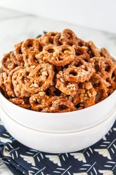 a white bowl filled with cereal on top of a blue and white table cloth next to a napkin