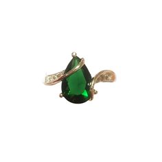 a ring with a green stone and two white diamonds on the side, set in gold