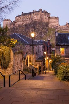 an alley way with stone buildings and street lights at dusk in edinburgh, scotland during the day