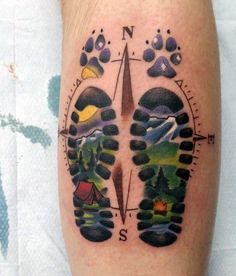 a person with a compass tattoo on their leg and foot is shown in the shape of a bear's paw