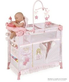 a baby in a pink crib with stars on the top and bottom shelf, holding a toy