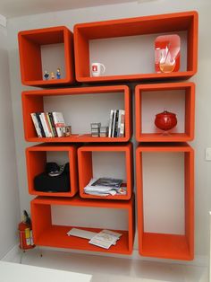 an orange shelving unit with books and magazines