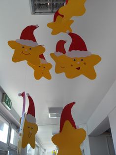 christmas decorations hanging from the ceiling with santa hats on them and smiling faces drawn on them