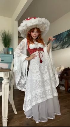 a woman in a white dress and large hat