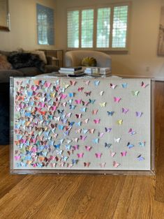 a box filled with lots of butterflies on top of a wooden table