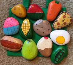 an assortment of colorful rocks and vegetables on a green tray