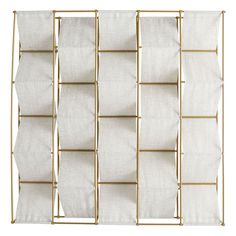 a gold metal rack with white linens hanging from it's sides on a white wall