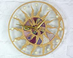 a gold clock with colorful designs on the face