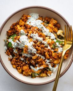 a white bowl filled with food next to a fork