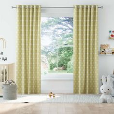 a child's room with yellow curtains and stuffed animals on the floor in front of it