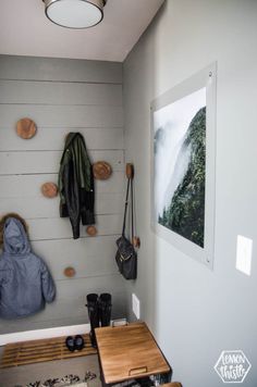 a coat rack is hanging on the wall next to a table with two purses