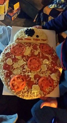 a person holding up a pizza with tomatoes and cheese on it