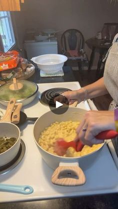 a woman is preparing food on the stove top in front of other bowls and pans