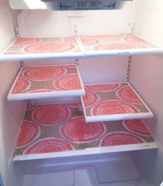 an open refrigerator with red and white designs on the shelves