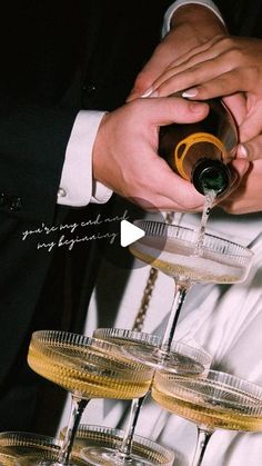 a man pouring champagne into wine glasses on top of a table filled with other drinks