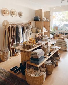 a room filled with lots of clothes and baskets on top of wooden shelves next to a window