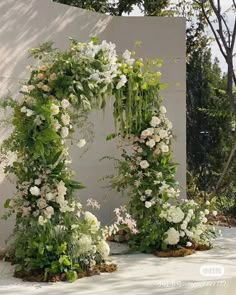 an outdoor wedding arch with white flowers and greenery