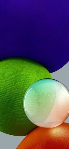 an abstract photograph of two different colored balls and one is white, green, orange and blue