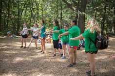 a group of girls in green shirts are playing frisbee golf on the ground