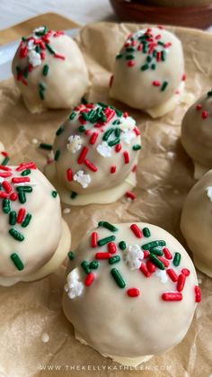 white chocolate covered donuts with red and green sprinkles on parchment paper