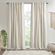 a living room with white curtains and rugs