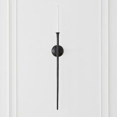 a door handle on a white door with black trim and an iron rod in the center