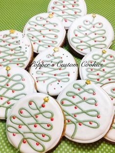 several decorated cookies sitting on top of a green tablecloth covered table next to each other