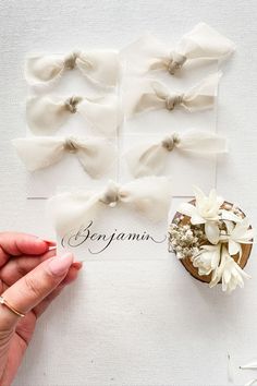 a person holding a card with bows on it and flowers in front of the cards