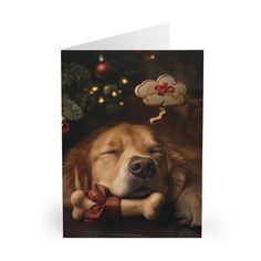 a card with a dog sleeping on it's side next to a christmas tree