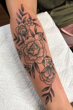 a black and white flower tattoo on the arm