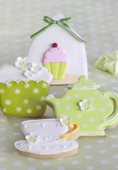 decorated cookies are sitting on a table with polka dot dots and green teapots