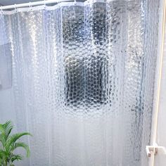 a bathroom with a shower curtain and a potted plant