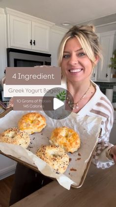 a woman holding a tray with four bagels on it and the words, 4 ingredient greek yogurt bread