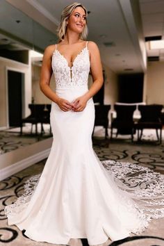 a woman in a white wedding dress posing for the camera with her hands on her hips