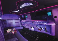 the inside of a limo with purple lights and decorations on it's walls, along with black leather seats