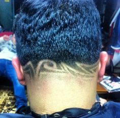 the back of a man's head with tattoos on it