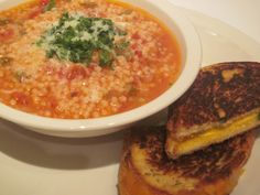 a bowl of soup and grilled cheese sandwich on a plate