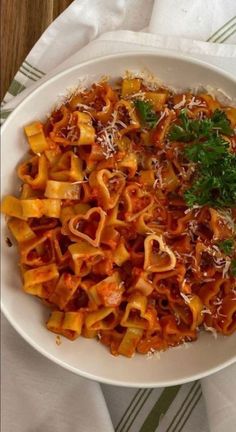 a white bowl filled with pasta and parmesan cheese on top of a table