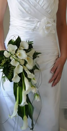 a bride holding a bouquet of white flowers