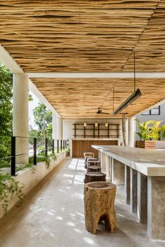 an outdoor covered area with benches and plants on the side wall, next to a bar